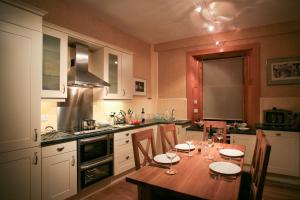a kitchen with a wooden table with chairs and a dining room at Crail Posthouse - 19th Century traditional house in Crail