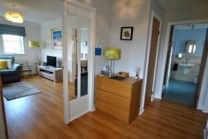 a living room with a wooden dresser and a living room at The Neuk- contemporary coastal apartment in Anstruther +16 photos