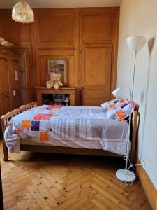 um quarto com uma cama com um candeeiro em Chambre chez l'habitant 3 em Biville-la-Baignarde