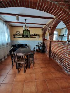 a dining room with a table and a brick wall at Vila Soleil in Smederevo