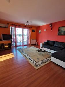 a living room with red walls and a couch at Vila Soleil in Smederevo