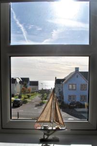 une fenêtre avec un voilier jouet devant elle dans l'établissement Forth View- stylish upper apartment with sea views, à Anstruther