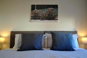 uma cama com almofadas azuis e um quadro por cima em Forth View- stylish upper apartment with sea views em Anstruther