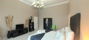 a bedroom with a bed and a chandelier at The Dream Guesthouse in Ermelo