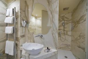 ein Bad mit einem Waschbecken und einer Dusche in der Unterkunft Park Hotel Imperial in Limone sul Garda