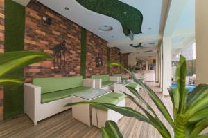 a restaurant with green chairs and a brick wall at God's Touch Apartments Signature in Lagos