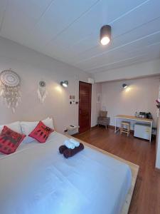 1 dormitorio con 1 cama blanca grande con almohadas rojas en Chiang mai Walking Street Home ( เชียงใหม่วอล์คกิ้งสตรีทโฮม ) en Chiang Mai