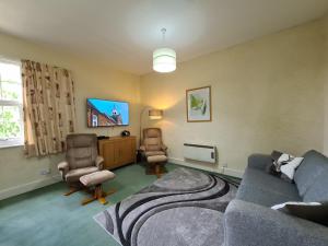 a living room with a couch and two chairs at Church Holiday Apartments in Robin Hood's Bay