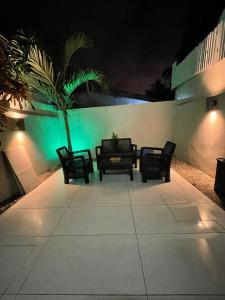 eine Terrasse mit Stühlen und einer Palme in der Nacht in der Unterkunft Résidence Palms Abidjan in Abidjan