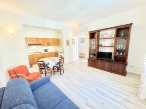 a living room with a blue couch and a table at Trilocale Jolly in Marina di Bibbona +13 photos