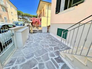 a stone walkway leading up to a building at Trilocale Jolly in Marina di Bibbona