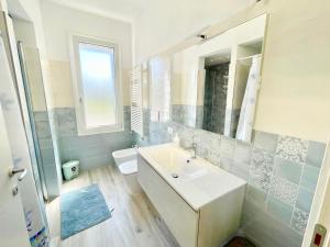 a bathroom with a sink and a toilet and a mirror at Trilocale Jolly in Marina di Bibbona