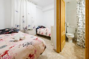 a bedroom with two beds and a toilet at Casa Campanilla Jaca in Jaca