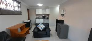 a living room with a black leather chair and a table at The Dream Guesthouse in Ermelo