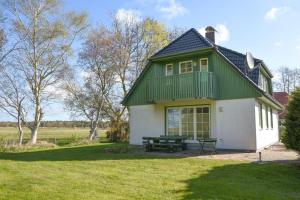 a green and white house with a picnic table in front of it at Dorfstr_ OT Mueggenburg in Klein Kirr