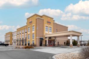 un gran edificio amarillo con aparcamiento en Comfort Suites & Conference Center, en Worthington