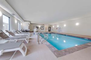 una piscina con tumbonas y una piscina en Comfort Suites & Conference Center, en Worthington