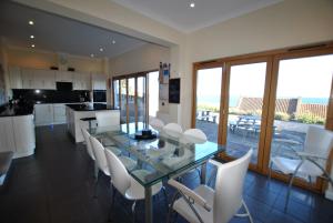 a kitchen and dining room with a glass table and white chairs at Anchor House Pittenweem - luxurious 4 bedroom in Pittenweem