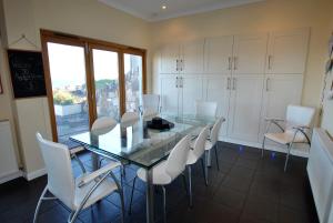 una sala da pranzo con tavolo in vetro e sedie bianche di Anchor House Pittenweem - luxurious 4 bedroom a Pittenweem