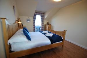 a bedroom with a bed with blue pillows on it at Anchor House Pittenweem - luxurious 4 bedroom in Pittenweem