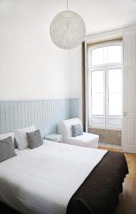Un dormitorio con una gran cama blanca y una ventana en Citybreak-apartments Bolhao, en Oporto