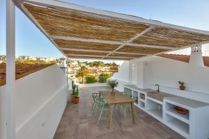 a patio with a wooden table and chairs at Casa Helena in Ferragudo