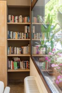 a book shelf filled with books next to a window at Hotel Domomea in Alghero