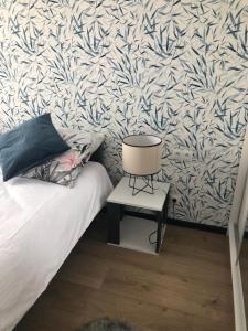 a bedroom with a bed and a table with a lamp at Apartament Pileckiego Nowy Dwór Mazowiecki Airport Modlin 24 H in Nowy Dwór Mazowiecki