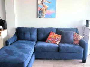 - un canapé bleu avec deux oreillers dans le salon dans l'établissement Direct Oceanfront With Balcony, à Daytona Beach