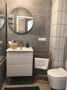 a bathroom with a sink and a toilet and a mirror at Apartament Pileckiego Nowy Dwór Mazowiecki Airport Modlin 24 H in Nowy Dwór Mazowiecki