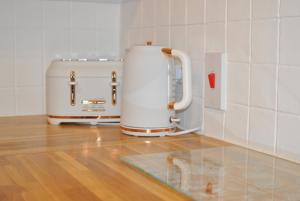 a kitchen with two toasters sitting on a wooden floor at Market Apartment- harbourfront studio Pittenweem in Pittenweem