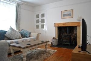 a living room with a couch and a fireplace at Craws Nest Cottage- stylish traditional home in Pittenweem