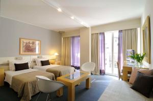 Dorian Inn - Sure Hotel Collection by Best Western في أثينا: غرفة فندقية بسريرين واريكة