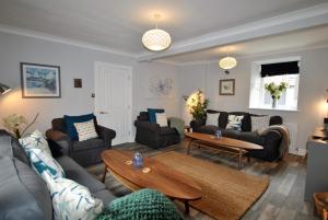 a living room with couches and a table at Misty Morn- stunning home in East Neuk in Anstruther