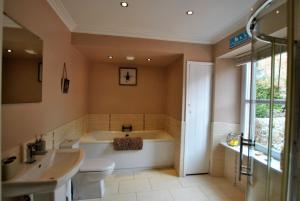a bathroom with a tub and a toilet and a sink at Misty Morn- stunning home in East Neuk in Anstruther +34 photos