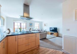a kitchen and living room with a couch and a stove at Coastal Haven- stunning home in Crail in Crail