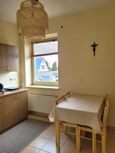 a kitchen with a table and a cross on the wall at Jono Pauliaus II piligrimu namai in Raseiniai