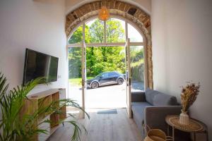 een woonkamer met uitzicht op een auto door een deur bij Stunning stone coach house in Marple
