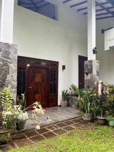 a front door of a house with potted plants at Rustic Mahaweli in Kandy