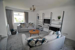 ein Wohnzimmer mit einem Sofa und einem Tisch in der Unterkunft Mariners Retreat- spacious apartment in Crail in Crail