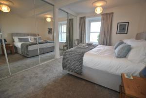 1 dormitorio con 2 camas y espejo en Mariners Retreat- spacious apartment in Crail, en Crail