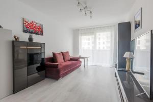 a living room with a red couch and a television at Central Apartments Silver L1F/21 in Gdańsk