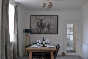 a dining room with a wooden table with wine glasses at Mariners Retreat- spacious apartment in Crail in Crail
