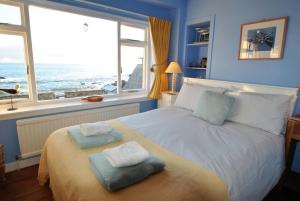 a bedroom with a bed with two towels on it at Catherine Cottage seaside home in Anstruther