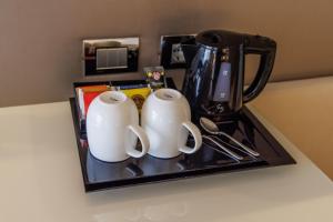 two white mugs sitting on a tray with a blender at Park Hotel Imperial in Limone sul Garda