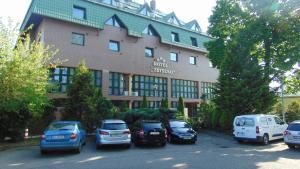 un grande edificio con macchine parcheggiate di fronte di Hotel Zbyszko a Stettino