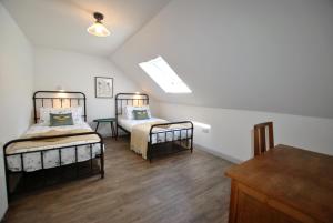 a attic room with two beds and a table at Puffin House- stylish home by the sea in Anstruther