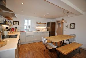 a kitchen with a wooden table and chairs in it at Puffin House- stylish home by the sea in Anstruther