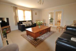 a living room with a couch and a coffee table at Orchard Cottage-spacious cottage in rural setting in Kilrenny
