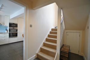 eine Treppe, die zu einer Küche mit weißen Wänden führt in der Unterkunft Seaglass Cottage-family friendly home in East Neuk in Pittenweem